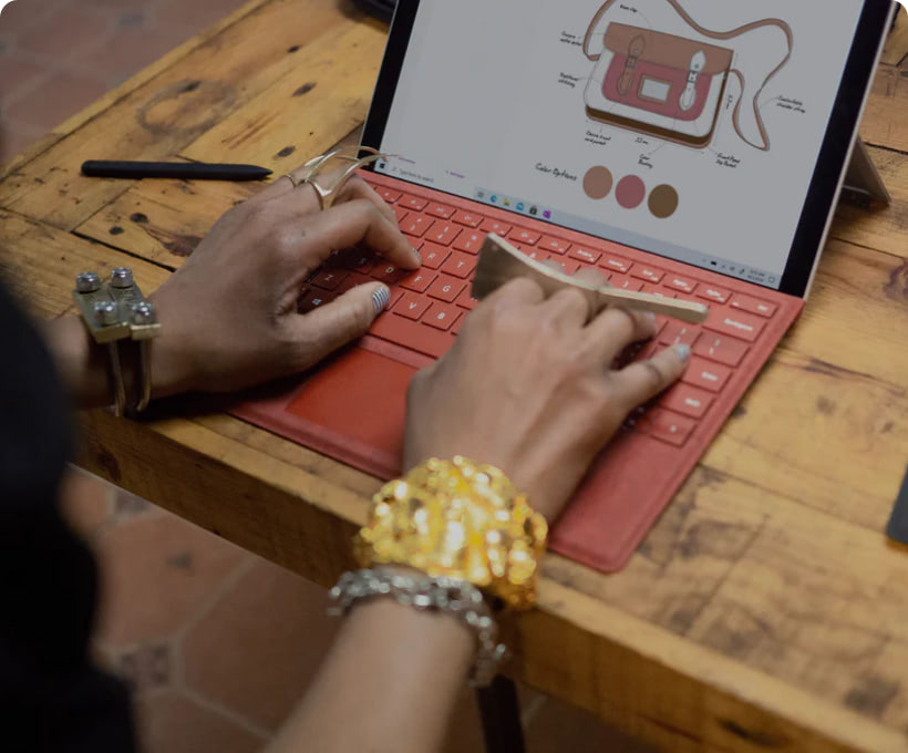 Une personne utilise une tablette devant un ordinateur portable.