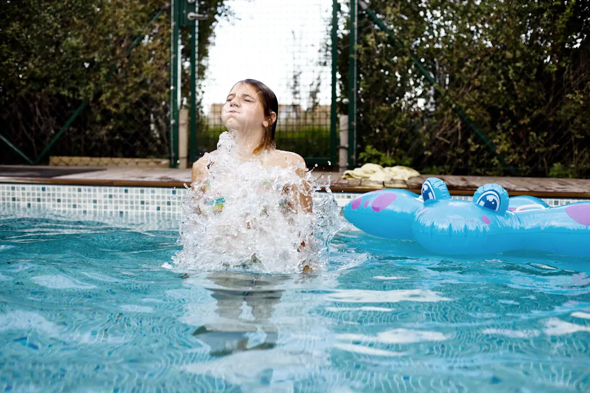 Jeune fille à la piscine risquant d'avaler de l'eau chlorée et développer des maux de ventre