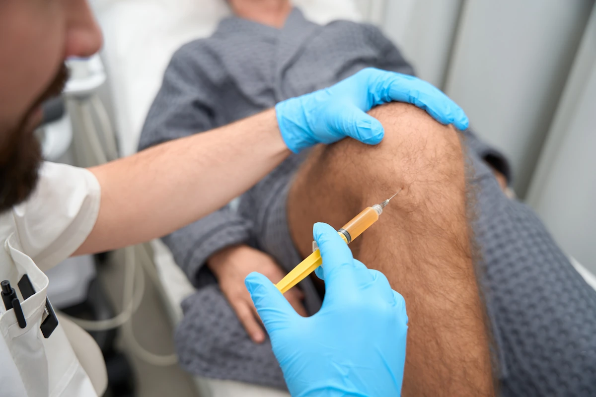 Un médecin qui injecte des corticoïdes dans le genou