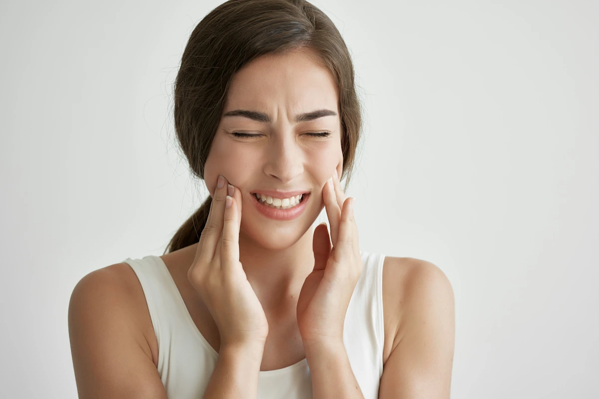 Une femme qui se tient la mâchoire