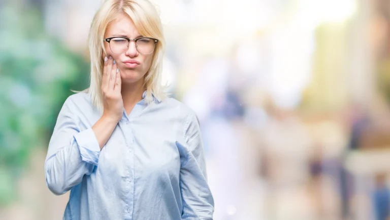 Une femme qui se tient la mâchoire