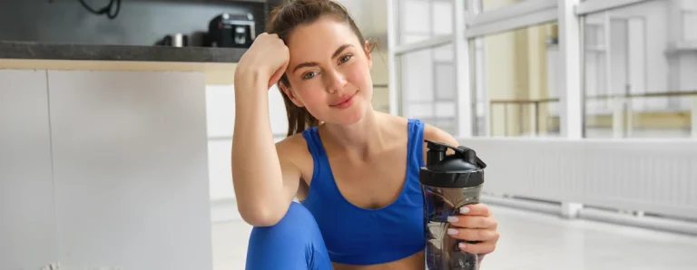 Une femme qui assise en tenant une bouteile