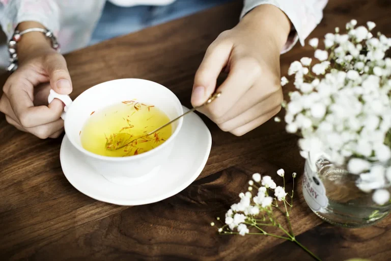 Une personne devant une tasse de tisane