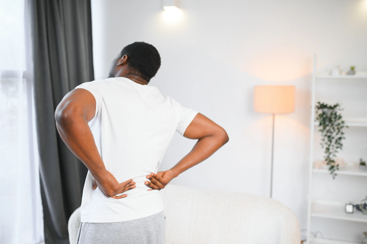 Un homme qui se tient le dos de douleur