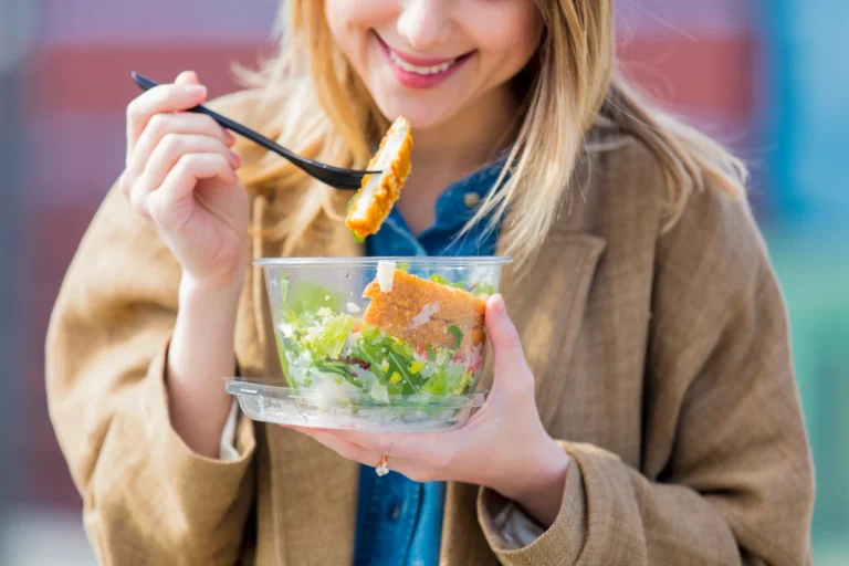 Une femme qui mange une assiette de salade