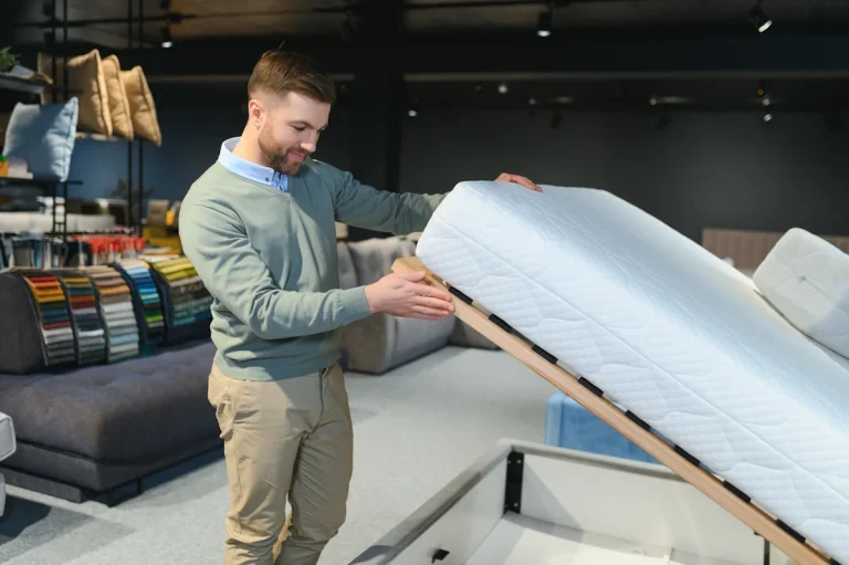 Un homme qui regarde un sommier avec un matelas en mousse