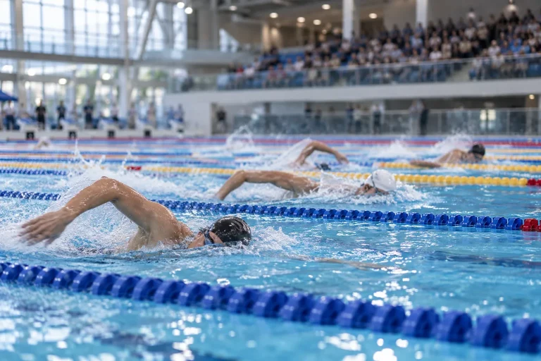 Des nageurs génériques disputent une course dans les couloirs d’une piscine intérieure.